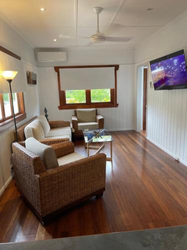 a living room with two couches and a flat screen tv at Manley St Suite in Redcliffe