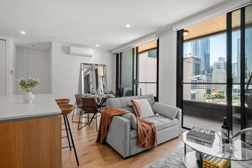 a kitchen and living room with a couch and a table at 2B2B Luxury at Flagstaff Gardens with Parking in Melbourne