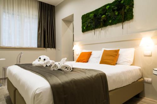 Un dormitorio con una cama grande con dos animales de peluche. en Aeterno Eco Guest House, en Roma