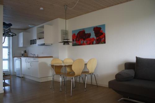 a kitchen with a table and chairs in a living room at Dancamps Nordsø Water Park in Hvide Sande