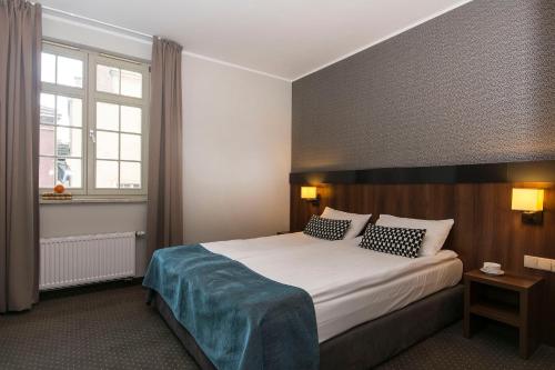a hotel room with a large bed and a window at Apart Neptun in Gdańsk