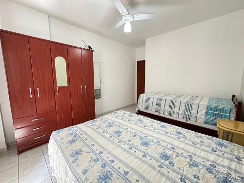ein Schlafzimmer mit zwei Betten und einem Deckenventilator in der Unterkunft Apto Próx. ao Mar na Guilhermina - Melhor Local in Praia Grande