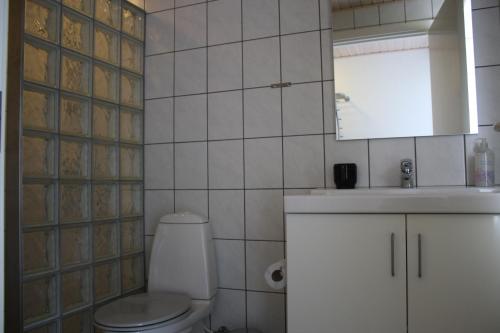 a white bathroom with a toilet and a sink at Dancamps Nordsø Water Park in Hvide Sande