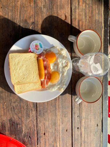 a plate of breakfast food with eggs and toast on a table at Battambang Eco Stay &cooking class in Battambang