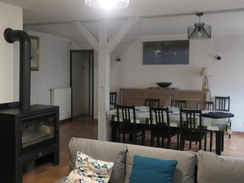 un salon avec un canapé et une salle à manger dans l'établissement Gîte familial près de l'étang des Bois avec cheminée et véranda chauffée - FR-1-590-89, à Vieilles-Maisons-sur-Joudry