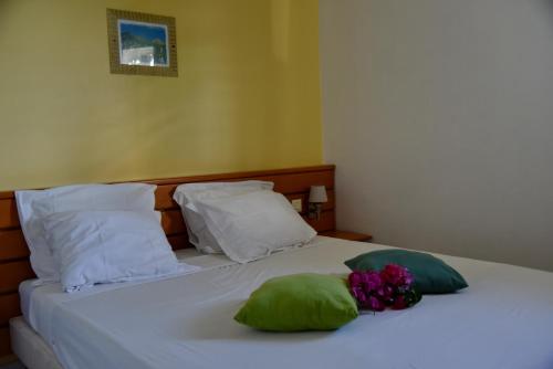 a bed with two pillows and a bouquet of flowers on it at Appartement Manganao beach in Saint-François