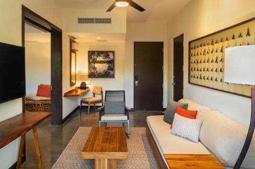 a living room with a couch and a table at El Mangroove Papagayo, Autograph Collection in Papagayo, Guanacaste