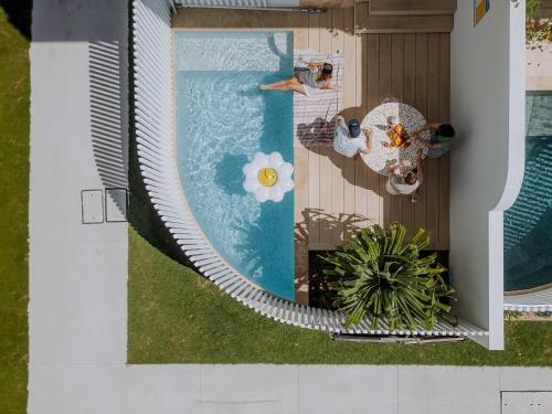 an overhead view of a swimming pool with a person laying on a chair at Bask at Burleigh in Gold Coast
