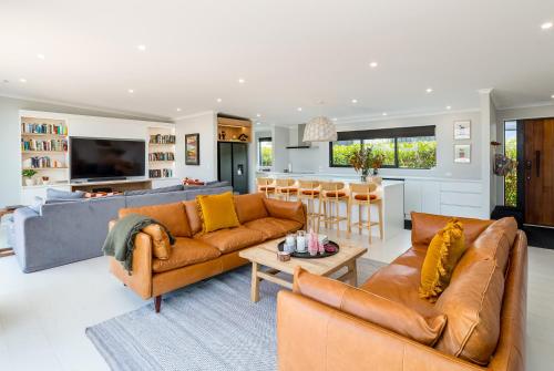 a living room with two couches and a kitchen at Sotally Tober Retreat in Martinborough 