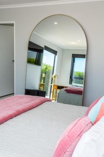 a bedroom with a bed and a large mirror at Sotally Tober Retreat in Martinborough 
