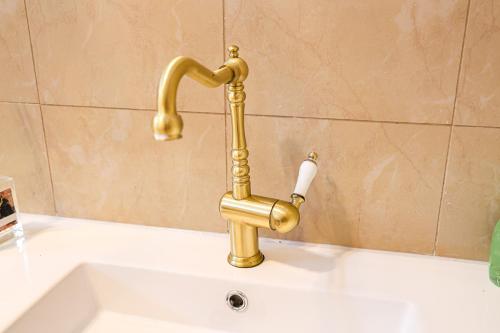 a gold faucet on top of a bath tub at StayAU Family-Friendly 3BR Getaway in Malvern in Chadstone
