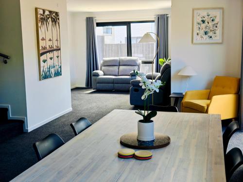 a living room with a table and a couch at New Built Gem in Hillcrest in Hamilton