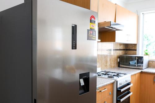 a stainless steel refrigerator in a kitchen at StayAU Family-Friendly 3BR Getaway in Malvern in Chadstone