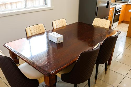 a wooden table with chairs around it in a room at StayAU Family-Friendly 3BR Getaway in Malvern in Chadstone