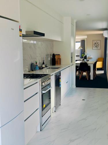 a kitchen with white cabinets and a stove top oven at New Built Gem in Hillcrest in Hamilton