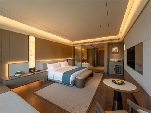 a bedroom with a bed and a living room at Yibo Jinling Hotel Moganshan in Huzhou