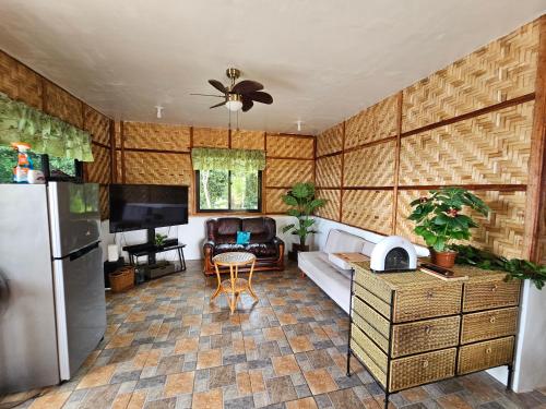 a kitchen with a refrigerator and a living room at Siquijor Cottage Lynn with Solar System in Maria