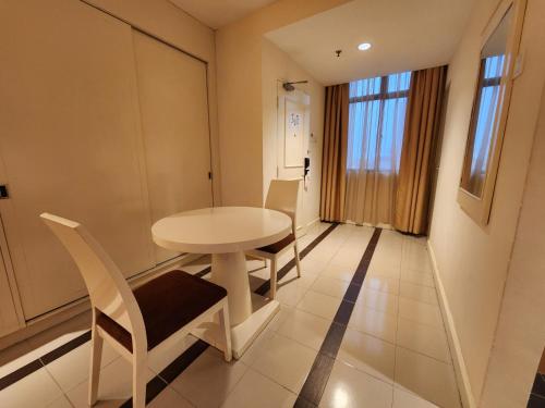 a small white table and chairs in a room at The Grand Puteri Hotel in Kuala Terengganu