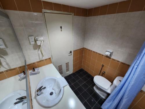 a bathroom with a white sink and a toilet at The Grand Puteri Hotel in Kuala Terengganu