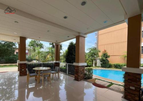 a patio with a table and chairs and a pool at Best Pet-Friendly Condo Near Puerto Princesa Airport - B2 6Diamond in Puerto Princesa City