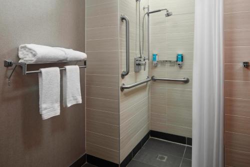 a bathroom with a shower with white towels at Aloft Buffalo Airport in Cheektowaga