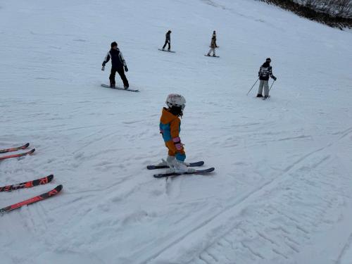 a group of people skiing down a snow covered slope at Ishiuchi Ski Center in Minami Uonuma