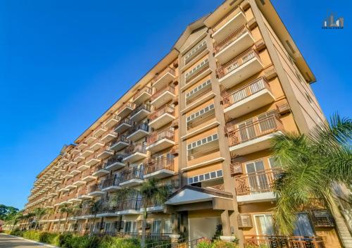 a tall building with palm trees in front of it at Palawan Luxury 2BR Condo with Pool, Gym & Parking - B1 5Kunzite in Puerto Princesa City