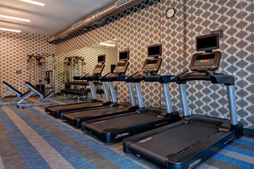 a gym with a row of treadmills and machines at Aloft Mooresville in Mooresville