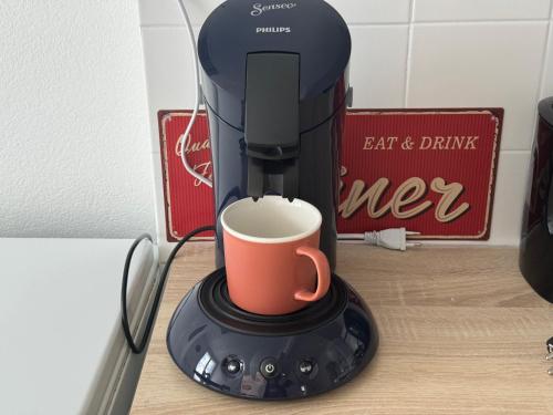 a coffee maker with a cup on a counter at Escale 42 in Le Mans