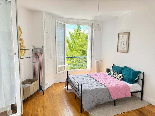 a bedroom with a bed and a window at Escale 42 in Le Mans