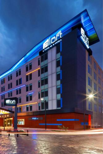 a hotel building with a lit up sign on it at Aloft Bogotá Airport in Bogotá