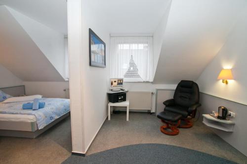 a bedroom with a bed and a chair and a desk at Landgasthaus Bonn in Baunatal