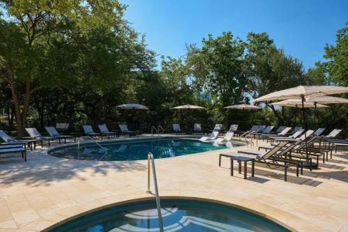 a swimming pool with lounge chairs and umbrellas at Renaissance Austin Hotel in Austin
