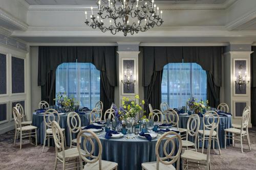 a dining room with blue tables and chairs and a chandelier at Renaissance Austin Hotel in Austin