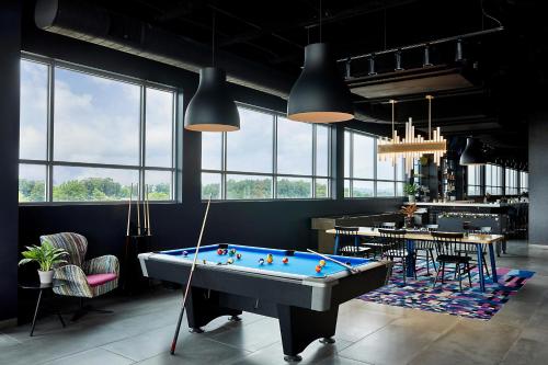 a billiard room with a pool table and a bar at Aloft Chattanooga Hamilton Place in Chattanooga