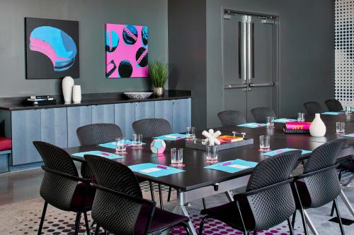 a dining room with a table and chairs at Aloft Chattanooga Hamilton Place in Chattanooga
