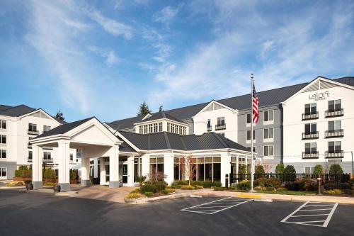 an exterior view of a hotel with an american flag at Aloft Mountain View in Mountain View