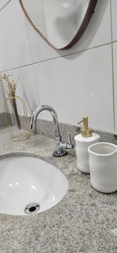 a bathroom counter with a sink and a mirror at Refúgio Secreto na Praia da Bacutia, Piscina, Churrasqueira, Ar condicionado 80m da melhor praia de Guarapari in Guarapari