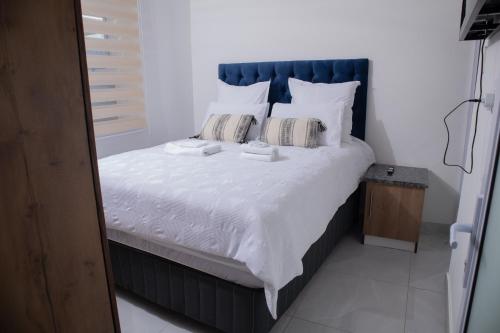 a bedroom with a large bed with white sheets and pillows at One Bedroom Apartment A4 in Cape Town