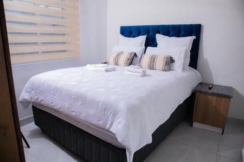 a bedroom with a large bed with white sheets and pillows at One Bedroom Apartment A4 in Cape Town