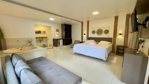a large room with a bed and a bath tub at Pousada Cristal da Terra in Sao Jorge