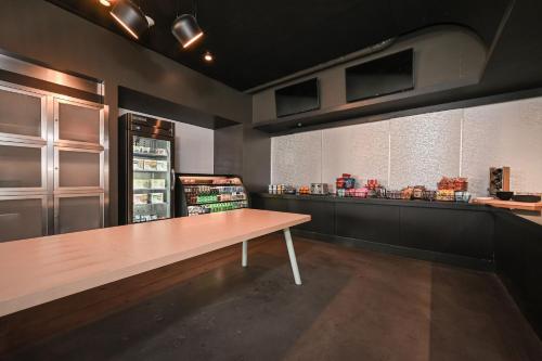 a kitchen with a table and a counter with food at Aloft Charlotte City Center in Charlotte
