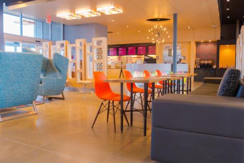 a restaurant with chairs and a table and a counter at Aloft Corpus Christi in Corpus Christi