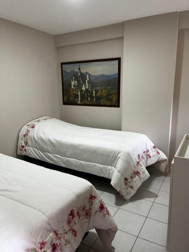 a bedroom with two beds and a painting on the wall at Tambaú Beach apartment in João Pessoa