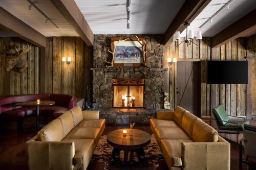 a living room with couches and a stone fireplace at The Virginian Lodge in Jackson