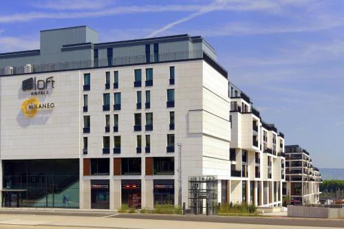 a large white building with a sign on it at Aloft Stuttgart in Stuttgart