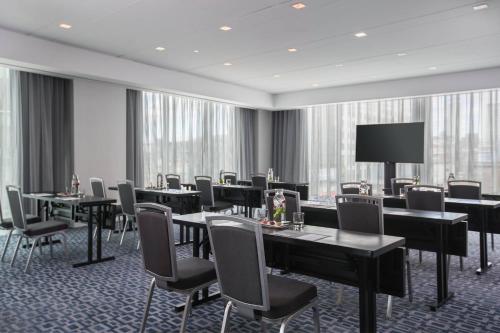 a conference room with tables and chairs and a screen at Renaissance Boston Seaport District in Boston