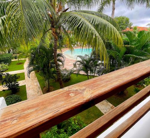 a view of a resort with a pool and palm trees at Bright Bayahibe condo with pool & beach in Bayahibe