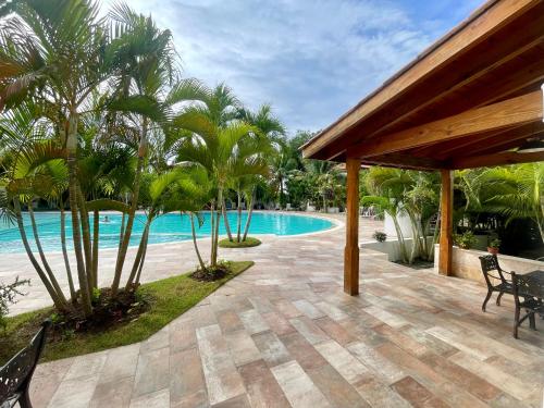 a resort with a swimming pool and palm trees at Bright Bayahibe condo with pool & beach in Bayahibe