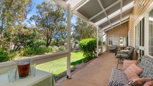 a porch with a table and chairs on a house at The Inn Between By Wine Coast Holidays in Port Willunga